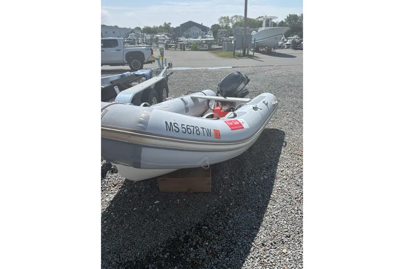 The Image of 2016 Zodiac Cadet RIB 340 PVC inflatable boat on gravel lot, for sale sign visible. - 0