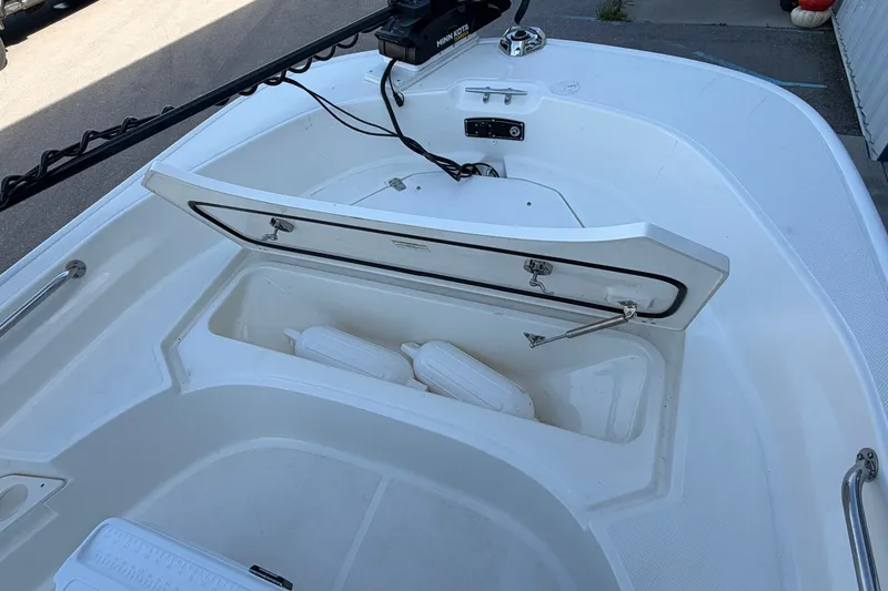 Slide: The Image of 2022 Boston Whaler 170 Montauk boat with open storage compartment and visible fenders. - 7
