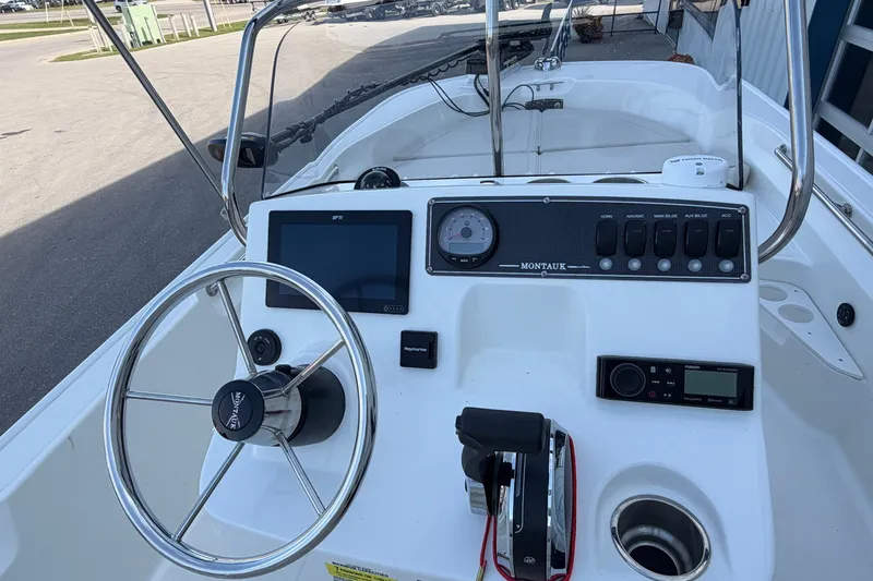 Slide: The Image of 2022 Boston Whaler 170 Montauk boat dashboard with steering wheel and control panel. - 18