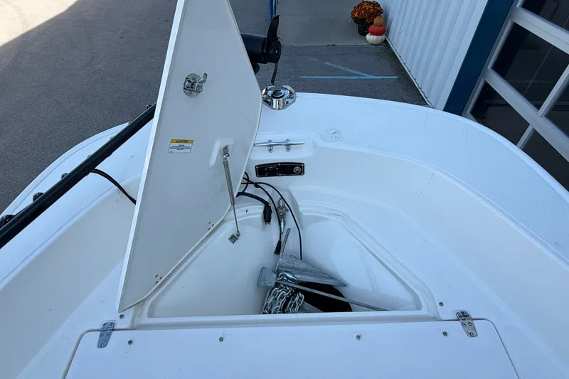 Slide: The Image of 2022 Boston Whaler 170 Montauk anchor storage compartment open, showcasing interior details. - 6