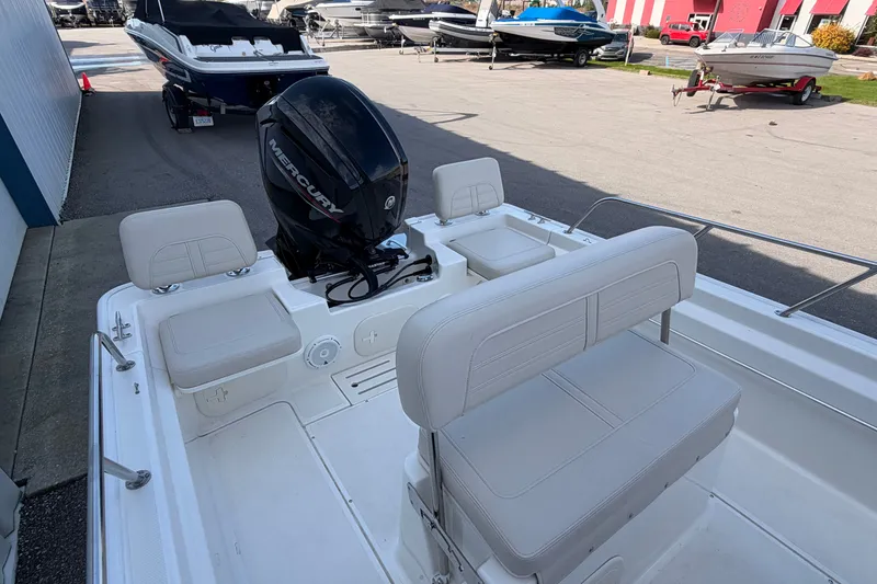 Slide: The Image of 2022 Boston Whaler 170 Montauk boat interior with Mercury engine, parked outdoors. - 13