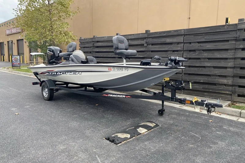 The Image of 2024 TRACKER MARINE Pro Team 175TF boat on trailer, parked near service center. - 0