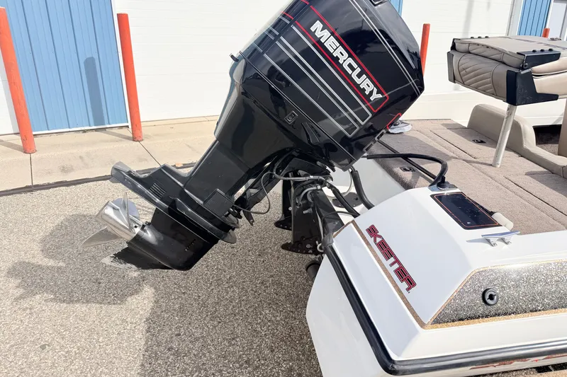 Slide: The Image of 1994 Skeeter SS140 boat with Mercury outboard motor, parked on pavement. - 13
