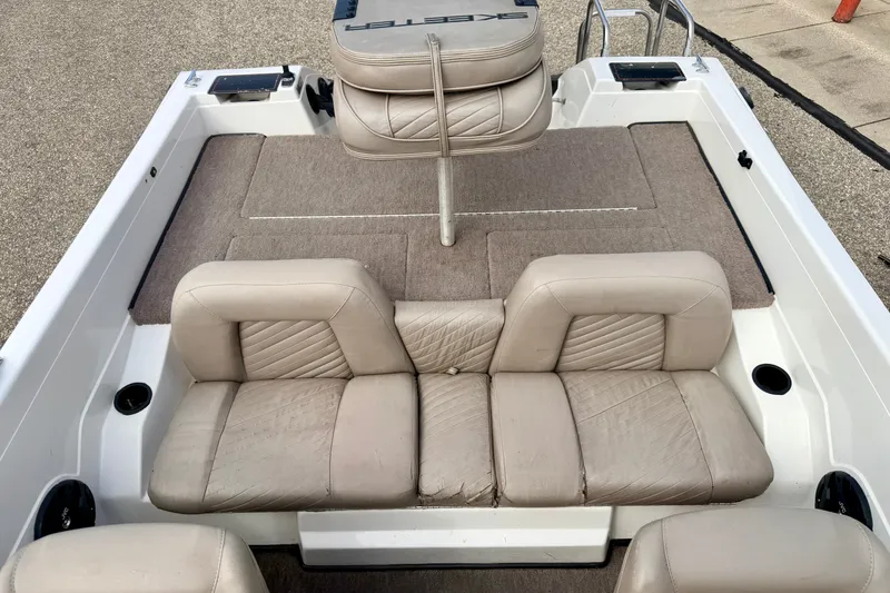 Slide: The Image of 1994 Skeeter SS140 boat interior with beige seating and carpeted flooring. - 70