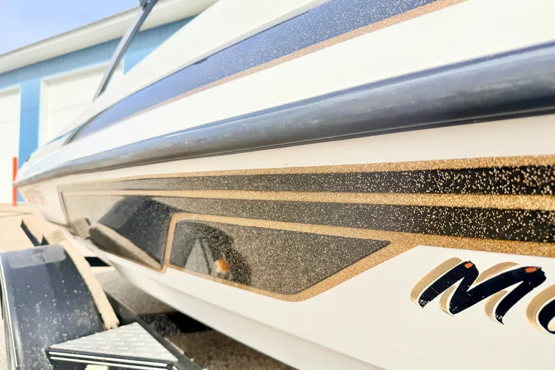 Slide: The Image of Close-up of a 1994 Skeeter SS140 boat with sleek black and gold detailing. - 9