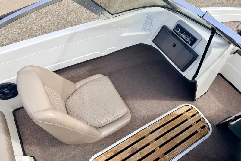 Slide: The Image of Interior of a 1994 Skeeter SS140 boat with beige seating and wooden flooring. - 47