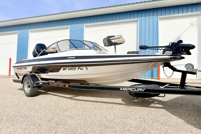 Slide: The Image of 1994 Skeeter SS140 boat on trailer, parked outside blue building. - 5