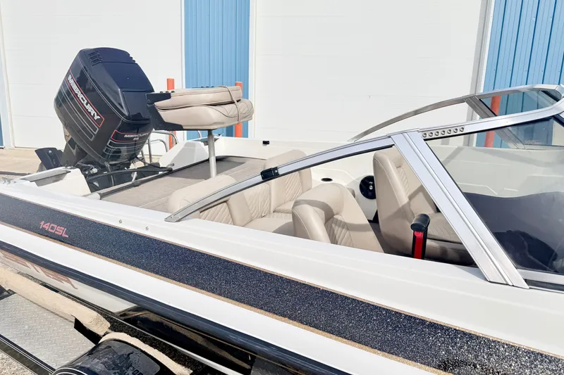 Slide: The Image of 1994 Skeeter SS140 boat with Mercury outboard motor, parked near blue garage doors. - 12