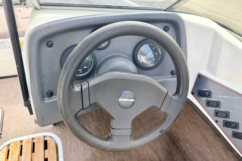 Slide: The Image of Steering wheel and dashboard of a 1994 Skeeter SS140 boat, featuring gauges and controls. - 42