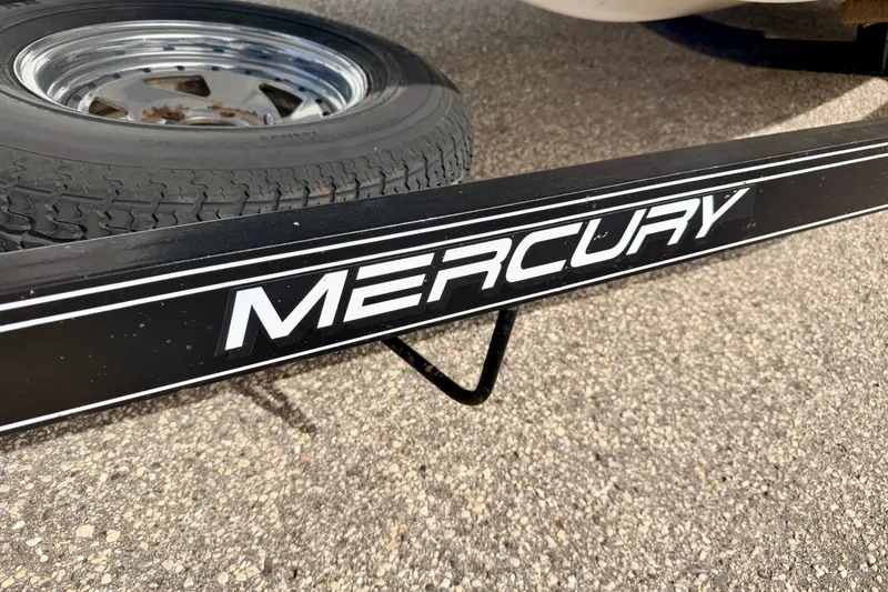 Slide: The Image of Trailer with "Mercury" branding beside a tire, related to 1994 Skeeter SS140 boat. - 73