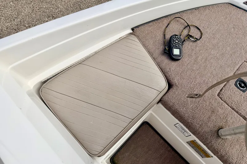 Slide: The Image of 1994 Skeeter SS140 boat interior with beige seat and control device on carpeted floor. - 54