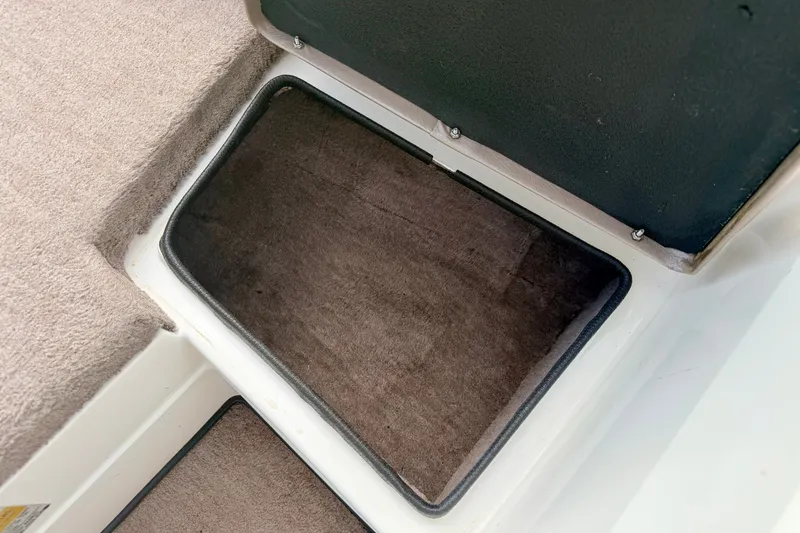 Slide: The Image of Storage compartment in a 1994 Skeeter SS140 boat, featuring carpeted interior. - 57