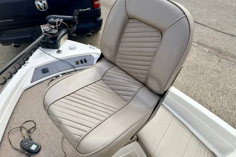 Slide: The Image of 1994 Skeeter SS140 boat seat with beige upholstery and control panel in view. - 53