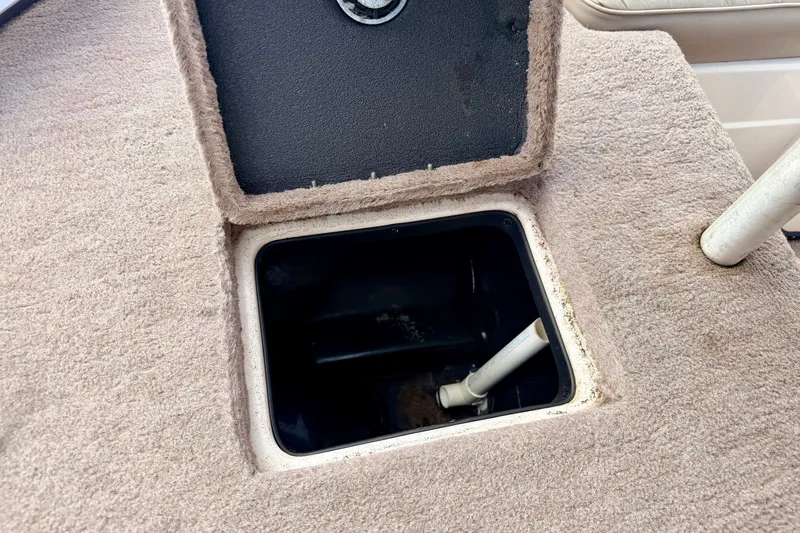 Slide: The Image of Open storage compartment on a 1994 Skeeter SS140 boat, featuring beige carpeted interior. - 65