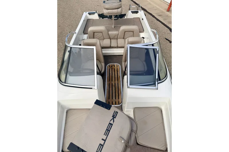 Slide: The Image of 1994 Skeeter SS140 boat interior with beige seating and open windshield. - 67