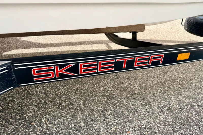Slide: The Image of Trailer of a 1994 Skeeter SS140 boat with bold red lettering. - 77