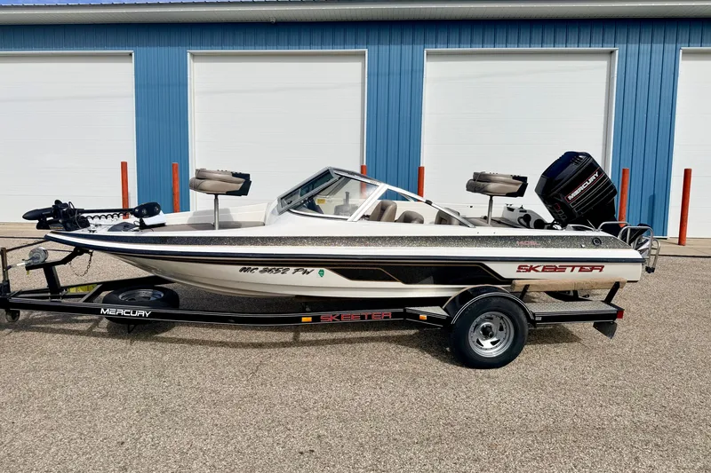 Slide: The Image of 1994 Skeeter SS140 boat with Mercury engine, parked outside blue garage doors. - 4