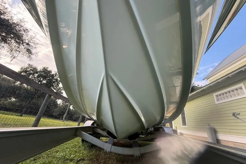 Slide: The Image of 2016 Sea Fox 246 Commander boat hull on trailer, side view near house and trees. - 3