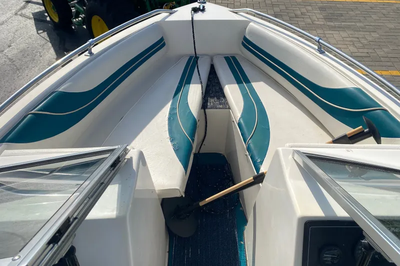 Slide: The Image of 1994 Sunbird Corsair 170 boat interior with teal and white seating, docked on pavement. - 9