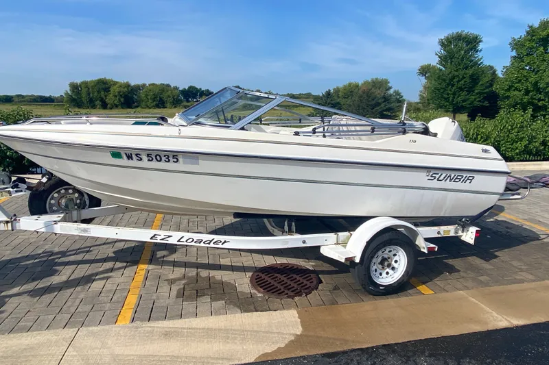 Slide: The Image of 1994 Sunbird Corsair 170 boat on trailer, parked outdoors on a sunny day. - 1