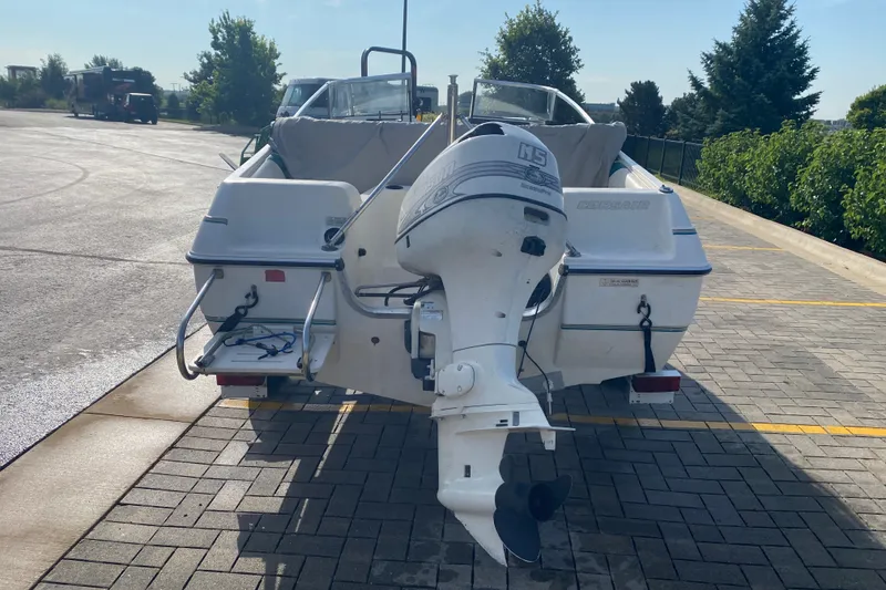 Slide: The Image of 1994 Sunbird Corsair 170 boat with outboard motor in a parking lot. - 4