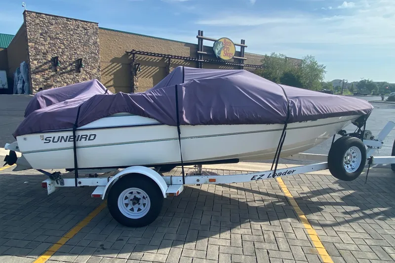 Slide: The Image of Covered 1994 Sunbird Corsair 170 boat on trailer in parking lot. - 3