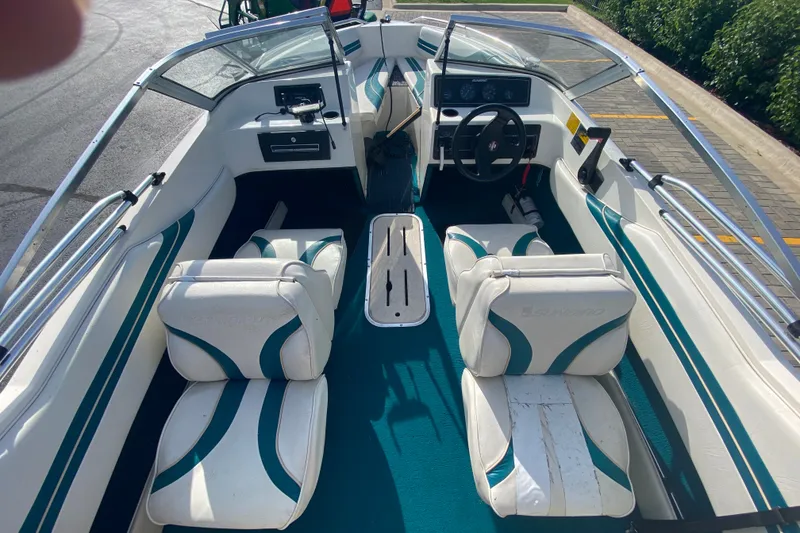 Slide: The Image of Interior of a 1994 Sunbird Corsair 170 boat with white and teal seating. - 6