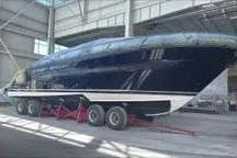 Slide: The Image of 2026 Tiara Yachts EX 54 in a shipyard, displayed on a trailer indoors. - 5