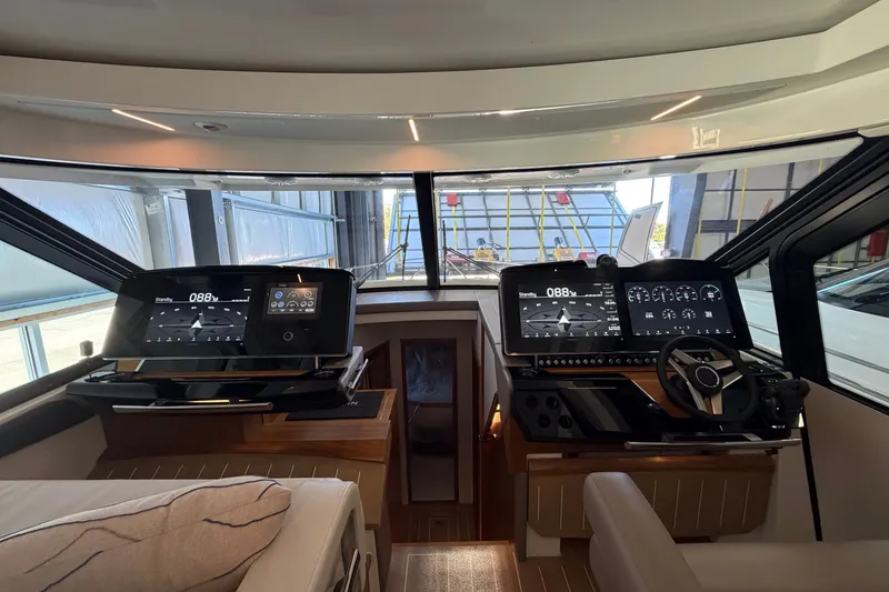Slide: The Image of Helm of 2026 Tiara Yachts EX 54 with advanced navigation displays and controls. - 10