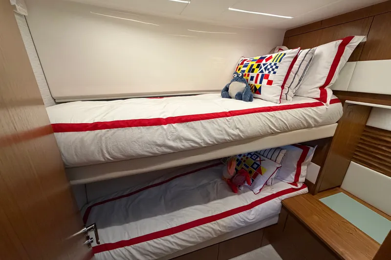 Slide: The Image of Bunk beds in 2026 Tiara Yachts EX 54, featuring nautical-themed bedding and plush toys. - 16