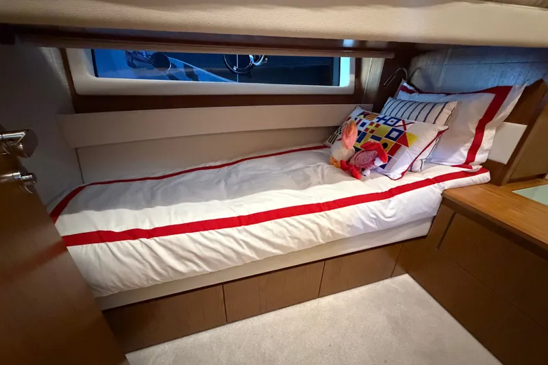 Slide: The Image of Cozy cabin interior of 2026 Tiara Yachts EX 54 with colorful bedding and window view. - 18