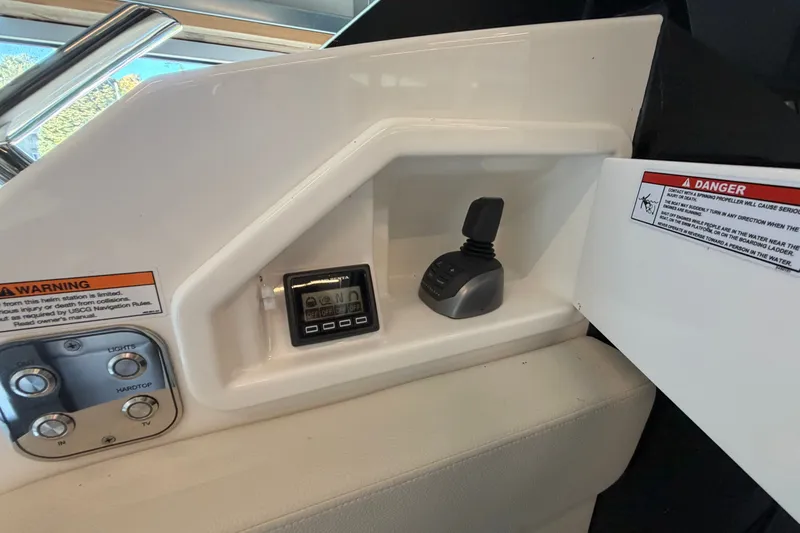 Slide: The Image of Control panel of 2026 Tiara Yachts EX 54 with warning labels and joystick. - 39