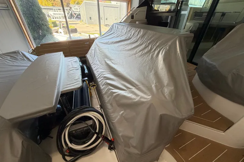Slide: The Image of Covered deck area of 2026 Tiara Yachts EX 54, showcasing protective tarps and coiled cables. - 43