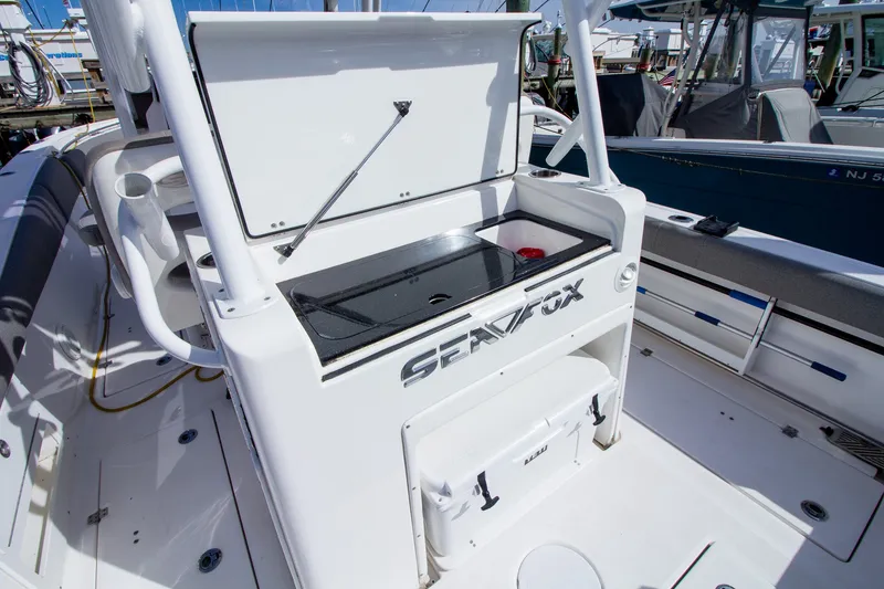 Slide: The Image of The image shows the cockpit of a 2019 Sea Fox 328 Commander with storage and a work surface. - 38
