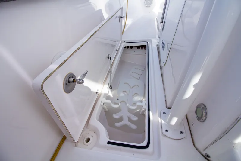 Slide: The Image of An open storage compartment on a boat with white walls and metal latches. - 18