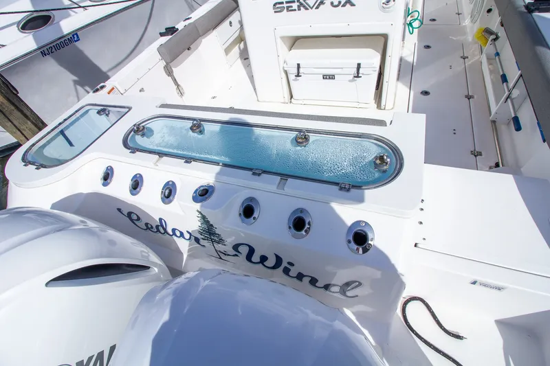 Slide: The Image of The image shows the stern of a Sea Fox 328 Commander boat with a livewell and multiple rod holders. - 44