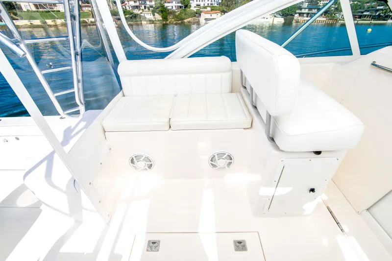 Slide: The Image of 2005 Cabo 35 Express boat interior with white seating and waterfront view. - 14
