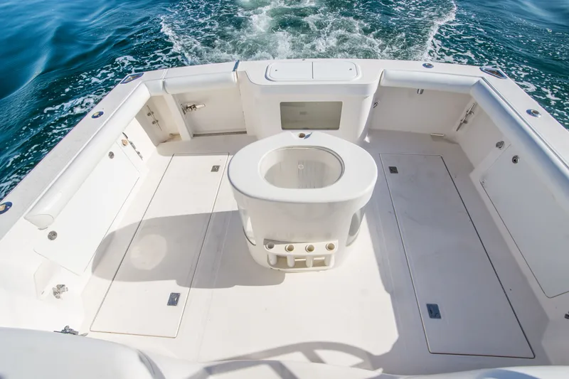 Slide: The Image of 2005 Cabo 35 Express boat deck with central livewell, surrounded by ocean water. - 9