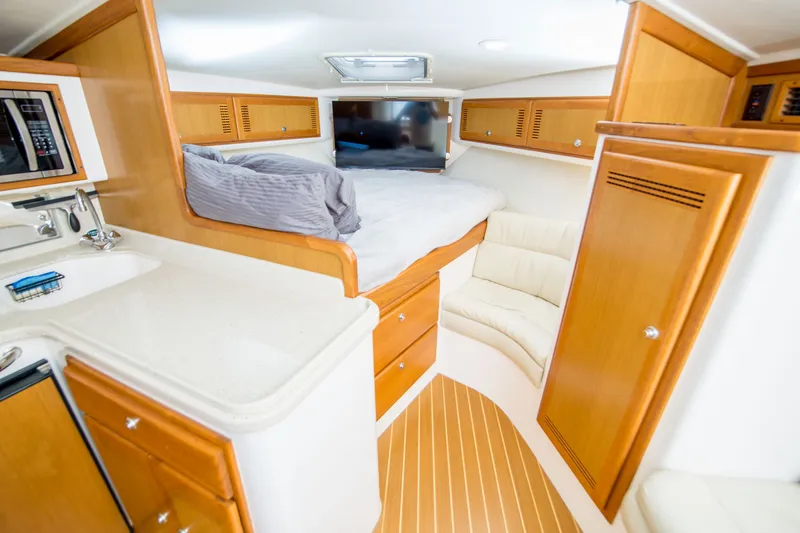 Slide: The Image of Interior of 2005 Cabo 35 Express boat with bed, seating, and kitchenette. - 19
