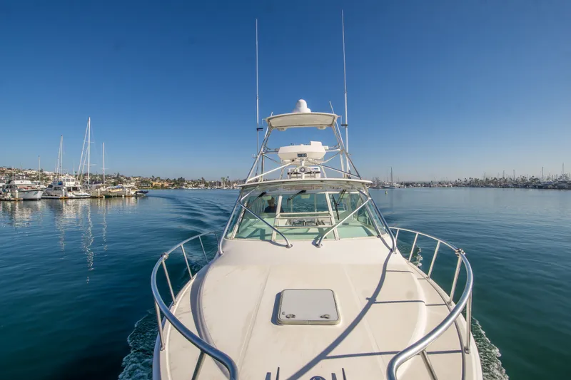 Slide: The Image of 2005 Cabo 35 Express yacht cruising in a serene marina under clear blue skies. - 5