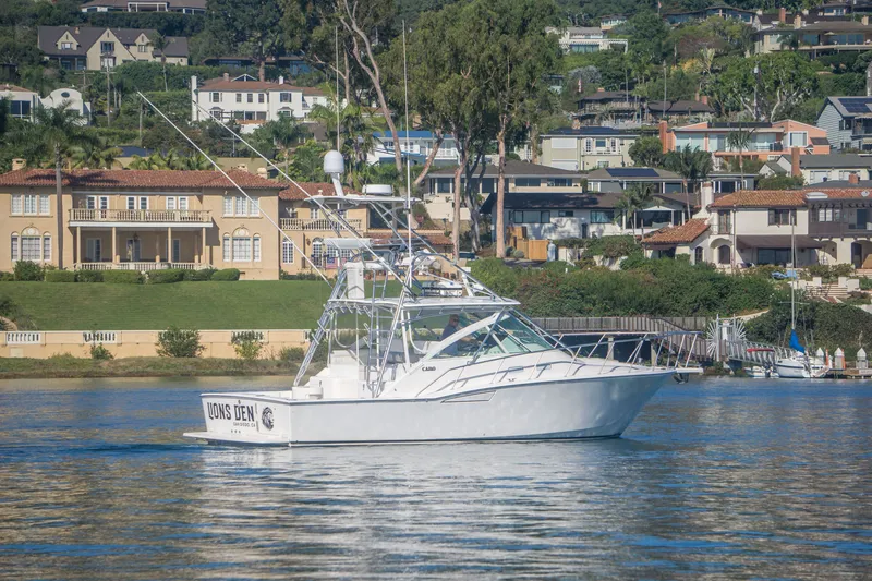Slide: The Image of 2005 Cabo 35 Express boat cruising near waterfront homes. - 2