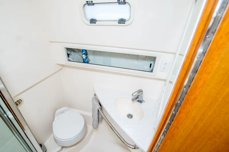 Slide: The Image of 2005 Cabo 35 Express yacht bathroom with toilet, sink, and window. - 22