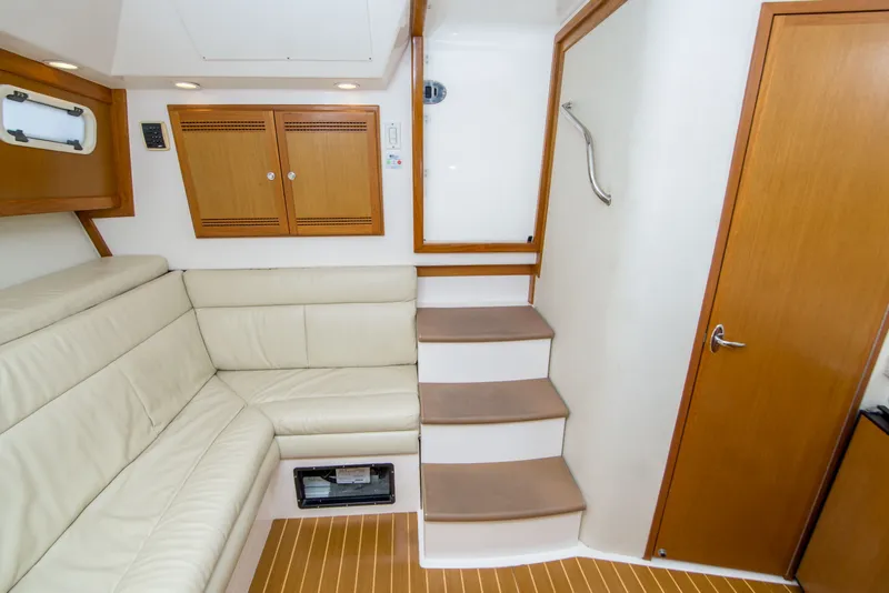 Slide: The Image of Interior of 2005 Cabo 35 Express yacht with beige seating and wooden cabinetry. - 28