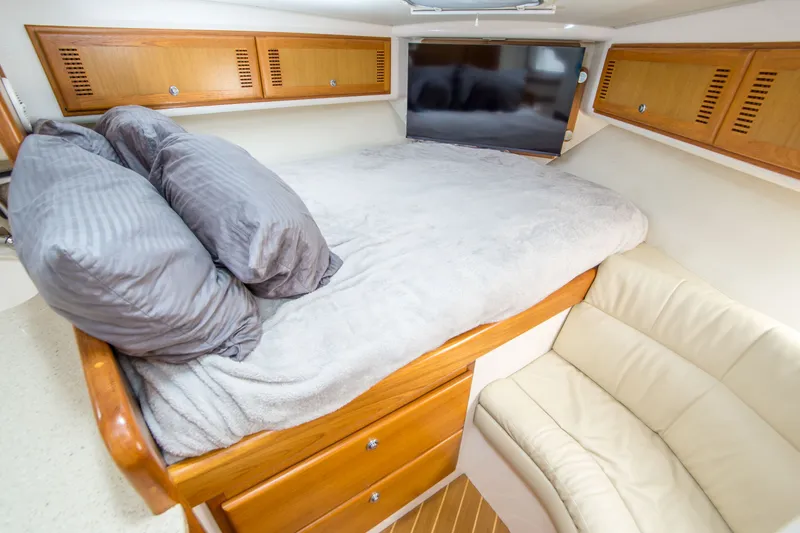 Slide: The Image of Cozy cabin interior of 2005 Cabo 35 Express with bed, pillows, and wooden storage. - 25