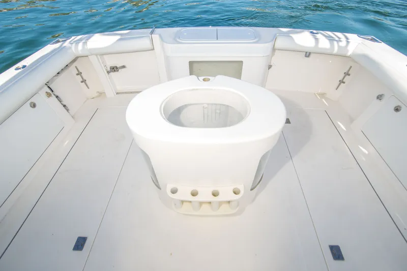 Slide: The Image of 2005 Cabo 35 Express boat deck with central seating, surrounded by calm water. - 18