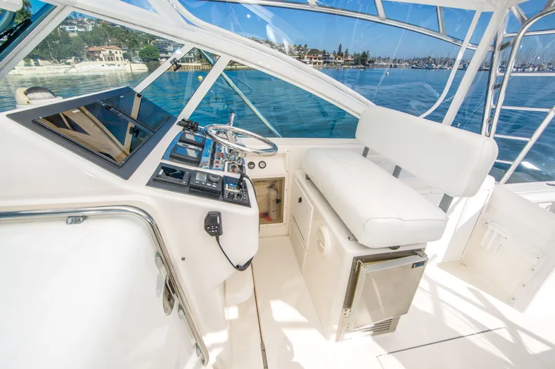 Slide: The Image of Helm of 2005 Cabo 35 Express boat with white seating and control panel. - 12