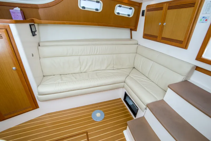 Slide: The Image of 2005 Cabo 35 Express interior with cream leather seating and wooden cabinetry. - 23