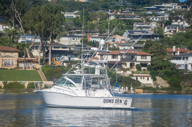 Slide: The Image of 2005 Cabo 35 Express boat on calm water with scenic residential backdrop. - 4