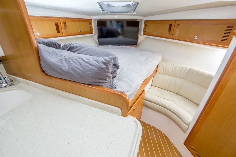 Slide: The Image of Luxurious interior of 2005 Cabo 35 Express yacht with cozy bed and seating area. - 26