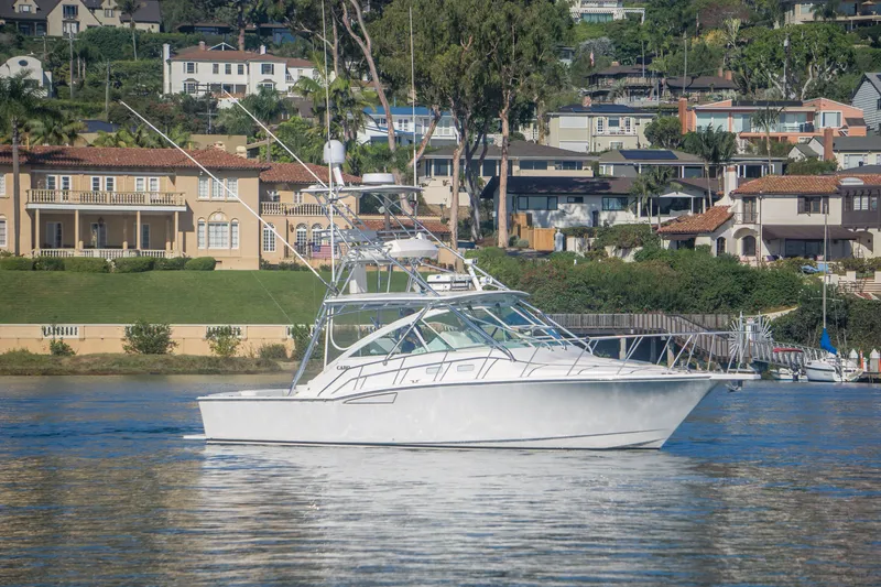 The Image of 2005 Cabo 35 Express yacht on calm water with scenic waterfront homes in the background. - 0